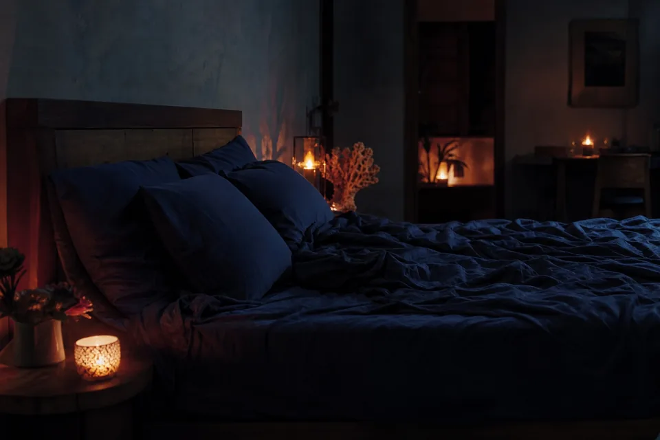 Candlelit bedroom with rumpled sheets